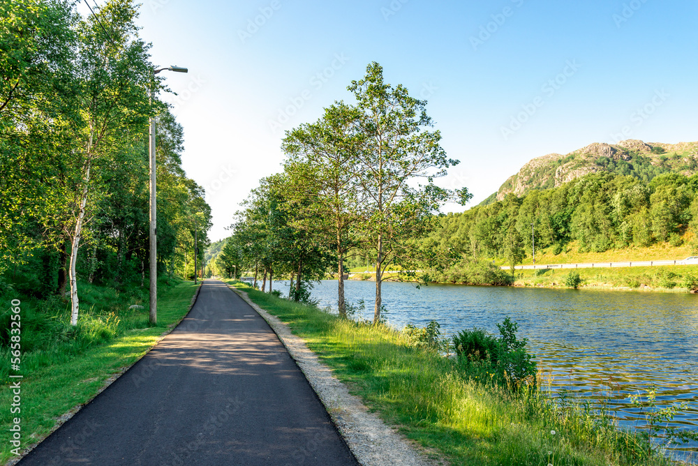 A footpath along scenic river running from Algard town, Norway, June 2018