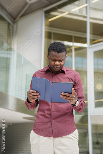 Businessman african man outside the office with a laptop in hand. Migrated people working