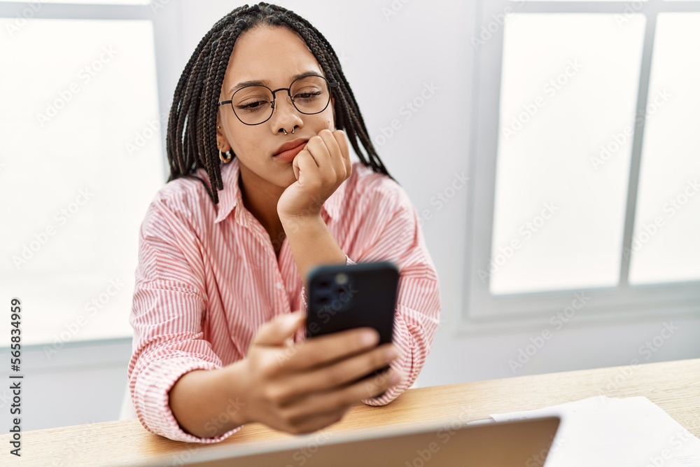 Young african american woman using smartphone working at office Young african american woman using smartphone working at office