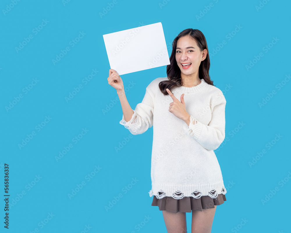 Your text here. Young excited woman holding empty blank board. Colorful studio portrait with light blue background. Woman holding blank empty banner pointing finger to one self smiling happy and proud Your text here. Young excited woman holding empty blank board. Colorful studio portrait with light blue background. Woman holding blank empty banner pointing finger to one self smiling happy and proud