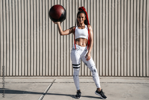 Full height. Athletic woman with med ball. Strength and motivation.Photo of sporty woman in fashionable sportswear