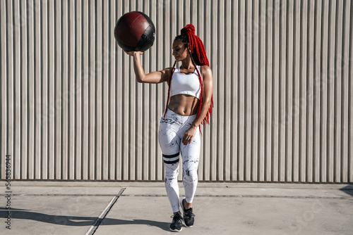 Full height. Athletic woman with med ball. Strength and motivation.Photo of sporty woman in fashionable sportswear