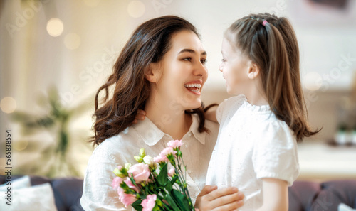 Daughter giving mother bouquet of flowers.