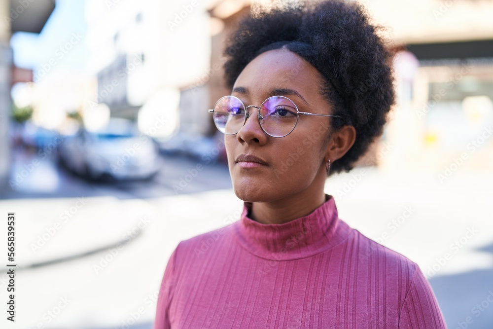 Fototapeta premium African american woman looking to the side with serious expression at street