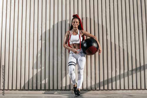 Full height. Athletic woman portrait with med ball. Strength and motivation.Photo of sporty woman in fashionable sportswear