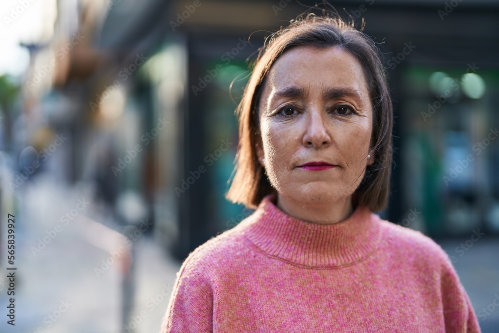 Middle age woman with relaxed expression standing at street Middle age woman with relaxed expression standing at street