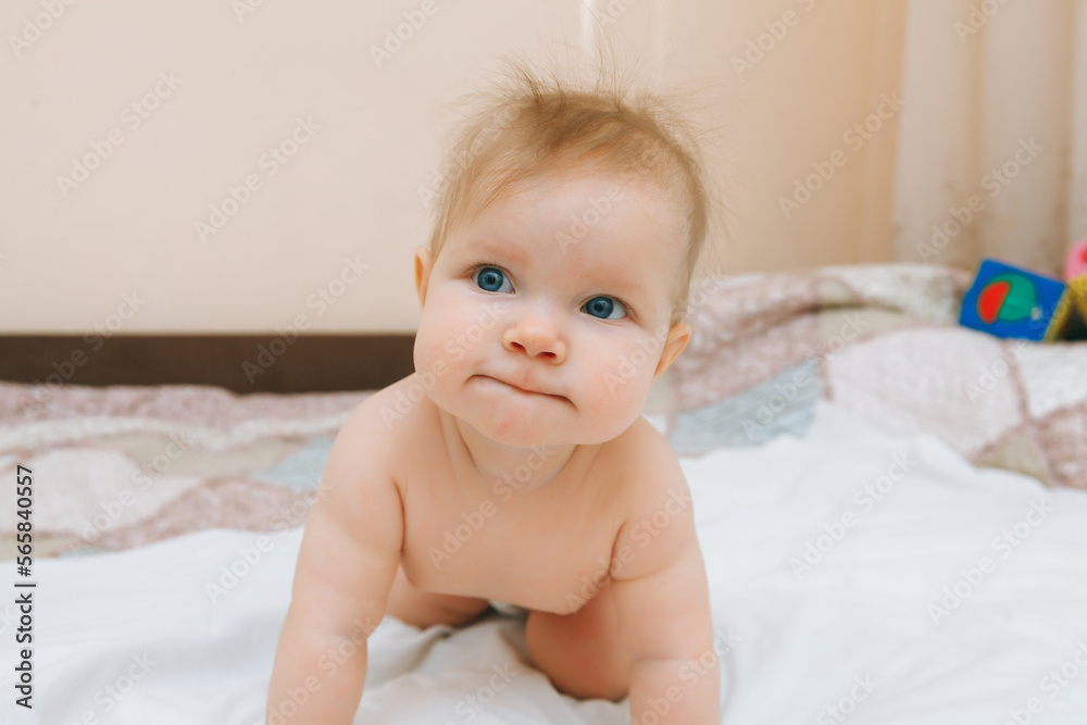 a funny baby crawling in the nursery at home. the baby is 6 months old learning to crawl a funny baby crawling in the nursery at home. the baby is 6 months old learning to crawl