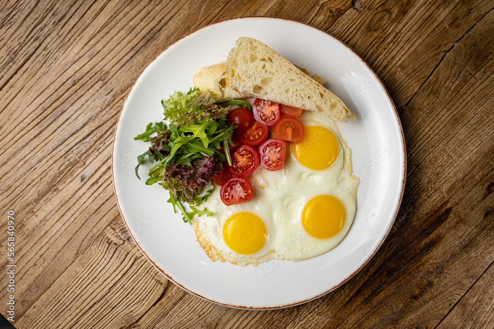 a delicious breakfast on a plate prepared in the restaurant. Fried eggs with tomatoes and salad
a delicious breakfast on a plate prepared in the restaurant. Fried eggs with tomatoes and salad