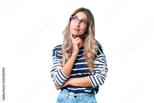 Young Uruguayan woman over isolated background having doubts while looking up