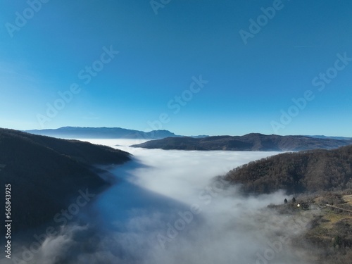 Aerial View. Flying over the high mountains in beautiful clouds. Aerial Drone camera shot. Air pollution clouds over Sarajevo in Bosnia and Herzegovina.  © .shock