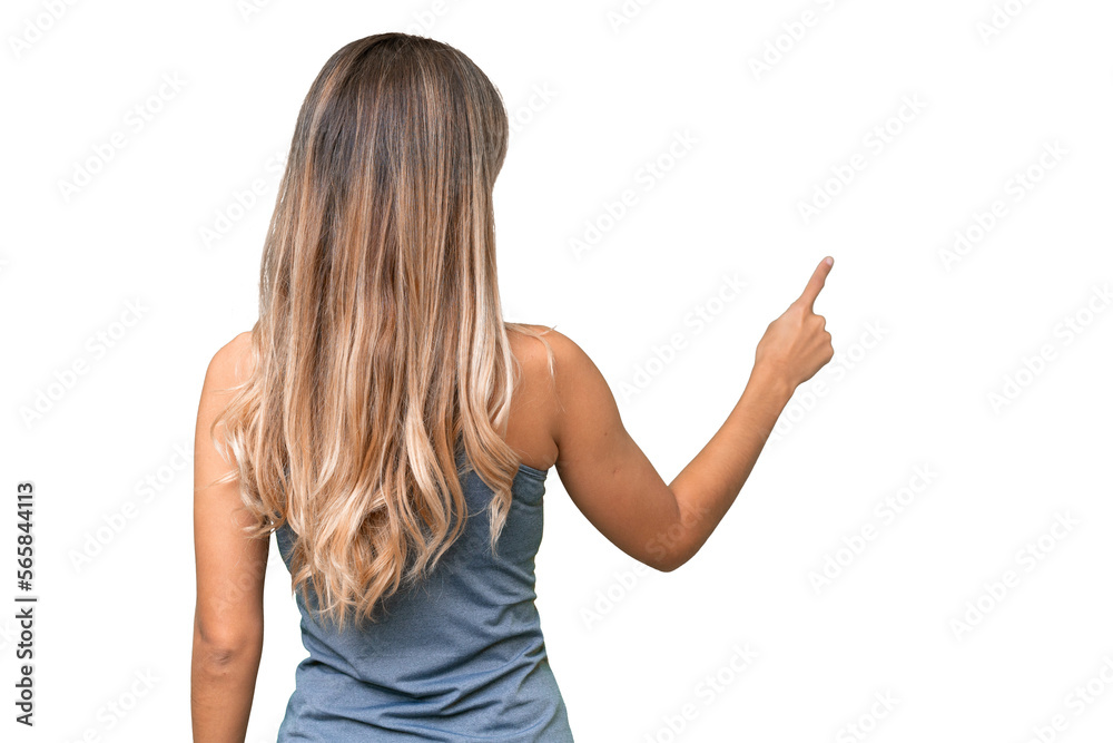 Young pretty sport Uruguayan woman with medals over isolated background pointing back with the index finger Young pretty sport Uruguayan woman with medals over isolated background pointing back with the index finger