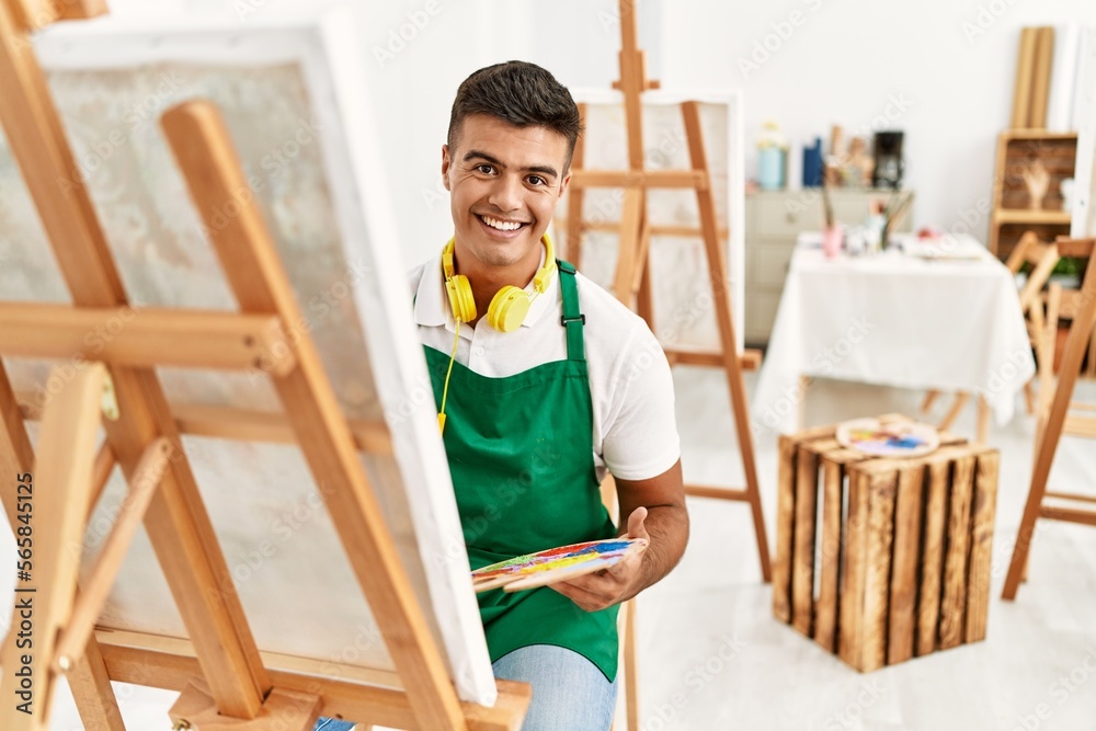 Young hispanic man smiling confident drawing at art studio
