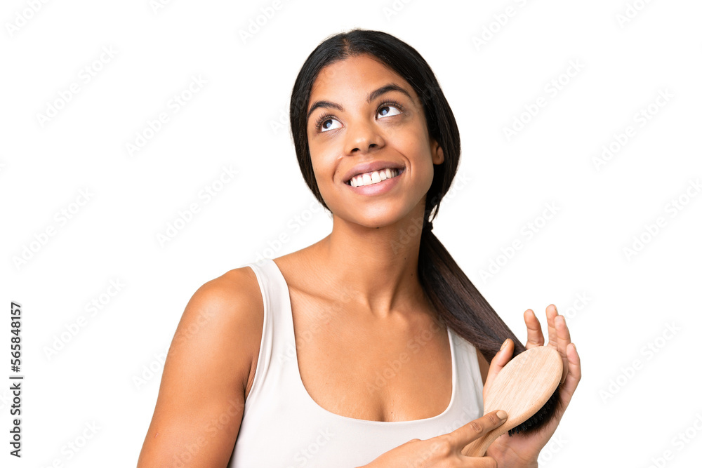 Young woman over over isolated chroma key background with hair comb Young woman over over isolated chroma key background with hair comb