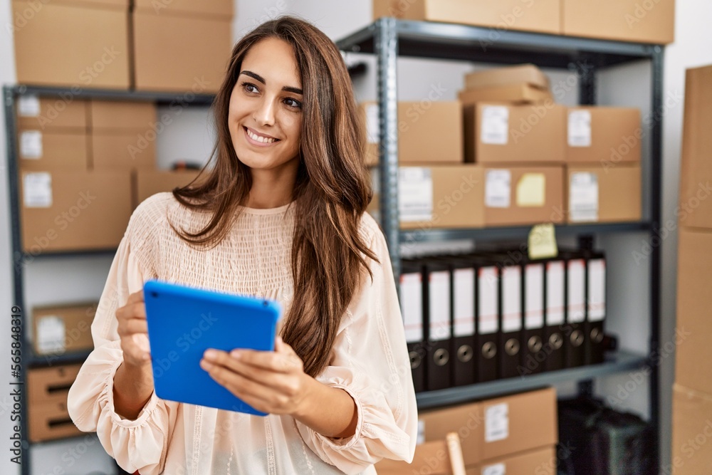 © Krakenimages.com - Young hispanic woman smiling confident using touchpad at storehouse