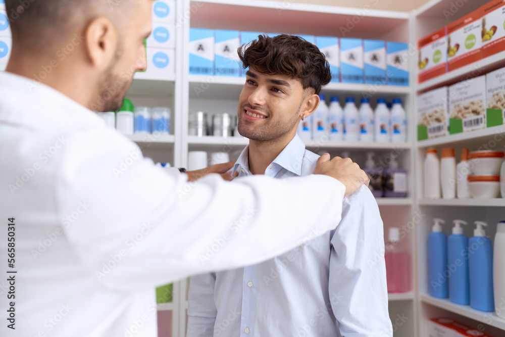 Two hispanic men pharmacist speaking to client at pharmacy
