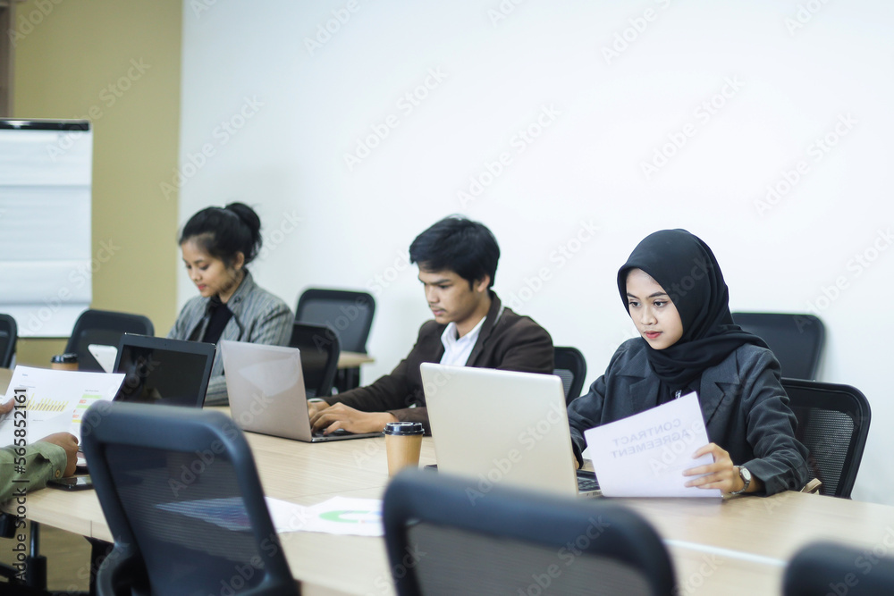 Business people working on laptop during meeting at office Business people working on laptop during meeting at office