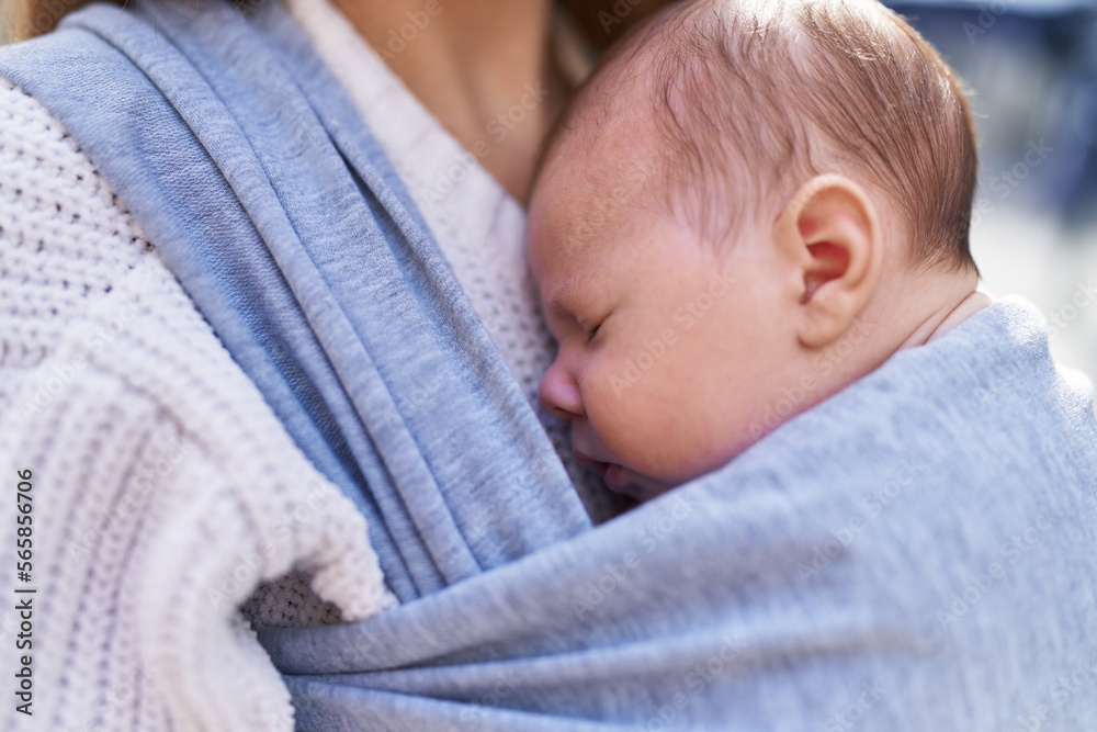 Mother and son sleeping baby standing at street Mother and son sleeping baby standing at street