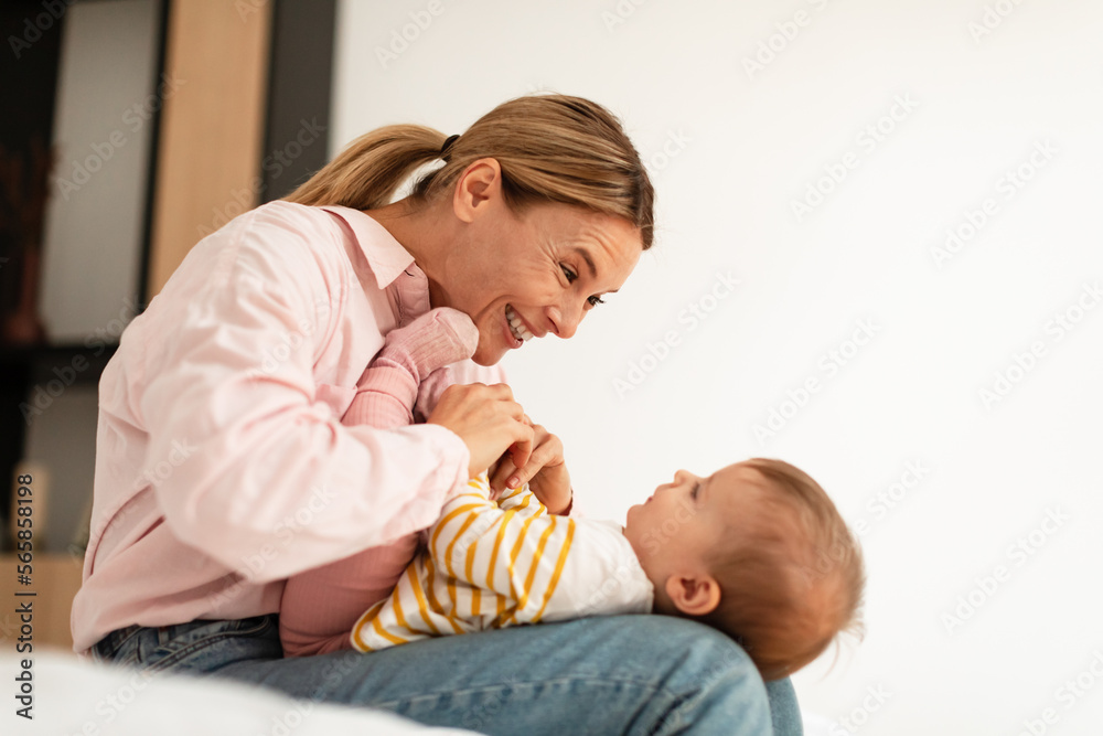 Lovely happy woman cuddling with her adorable baby girl, mother njoying child care during maternity leave Lovely happy woman cuddling with her adorable baby girl, mother njoying child care during maternity leave