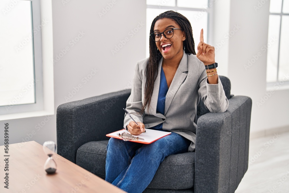 Young african american with braids working at consultation office pointing finger up with successful idea. exited and happy. number one. Young african american with braids working at consultation office pointing finger up with successful idea. exited and happy. number one.