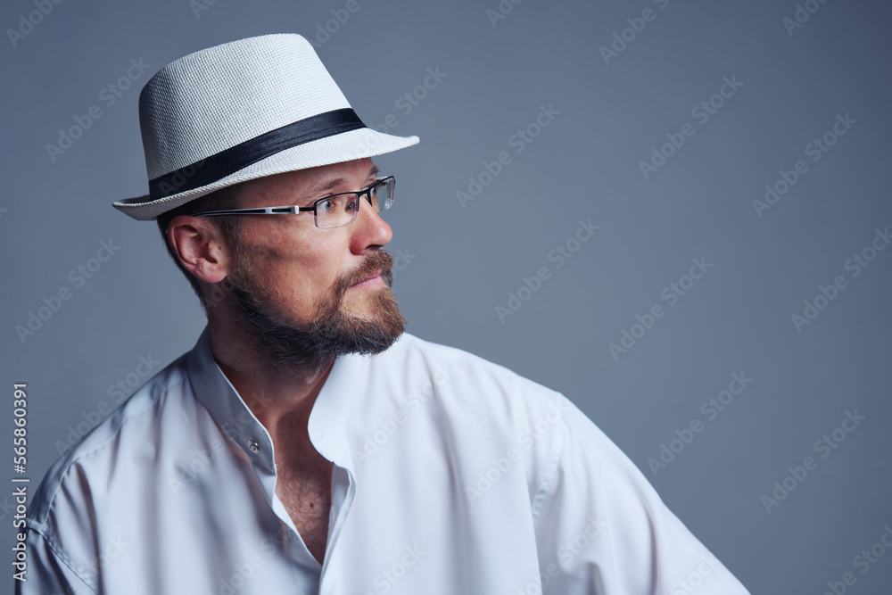 Confident serious middle age man in straw hat and eyeglasses looking at side Confident serious middle age man in straw hat and eyeglasses looking at side