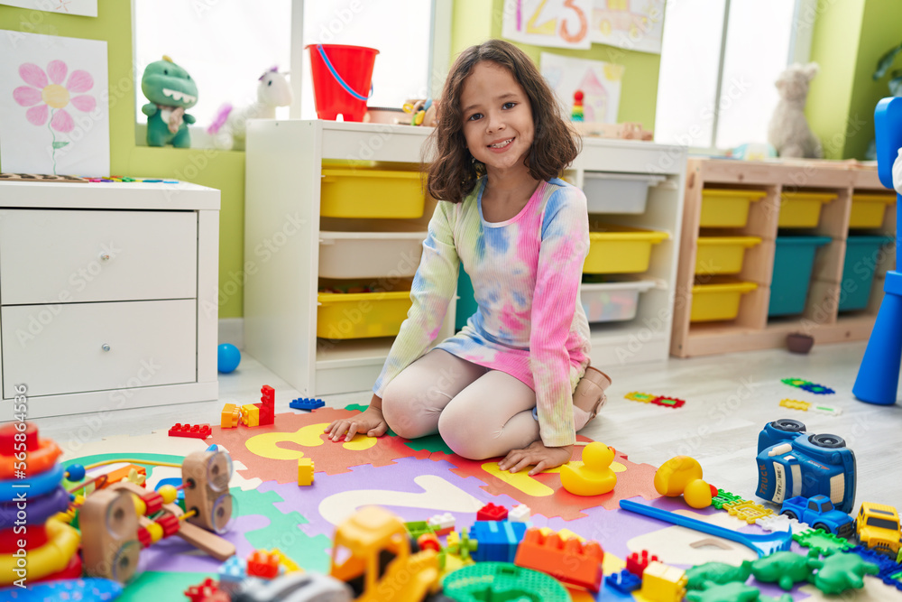 Fototapeta premium Adorable chinese girl smiling confident sitting on floor at kindergarten