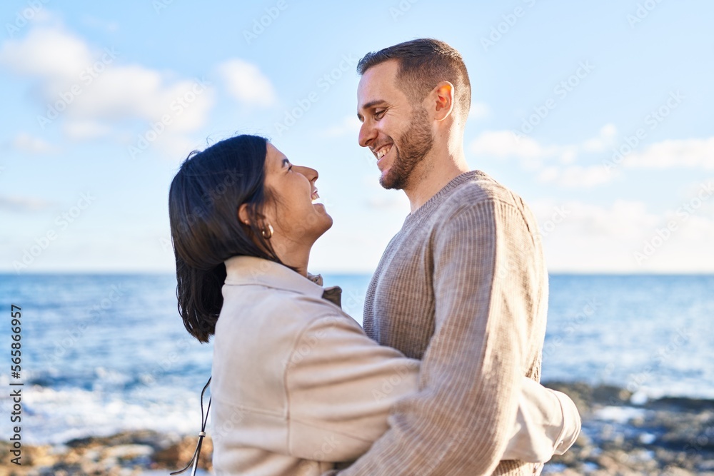 Man and woman couple smiling confident hugging each other standing at seaside Man and woman couple smiling confident hugging each other standing at seaside