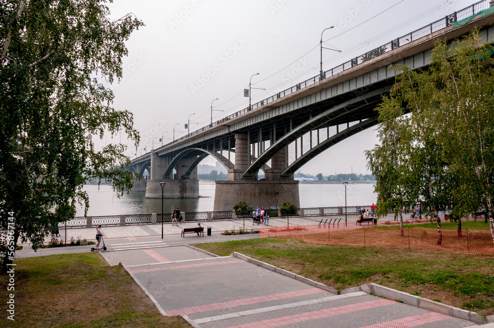 Fototapeta premium Novosibirsk, Russia, August 2022: Embankment in Novosibirsk and bridges across the Ob River in summer