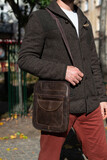 close-up photo of brown messanger leather bag on mans shoulder