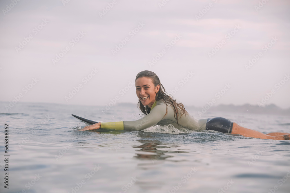Side view of woman lying on surfboard in sea Side view of woman lying on surfboard in sea