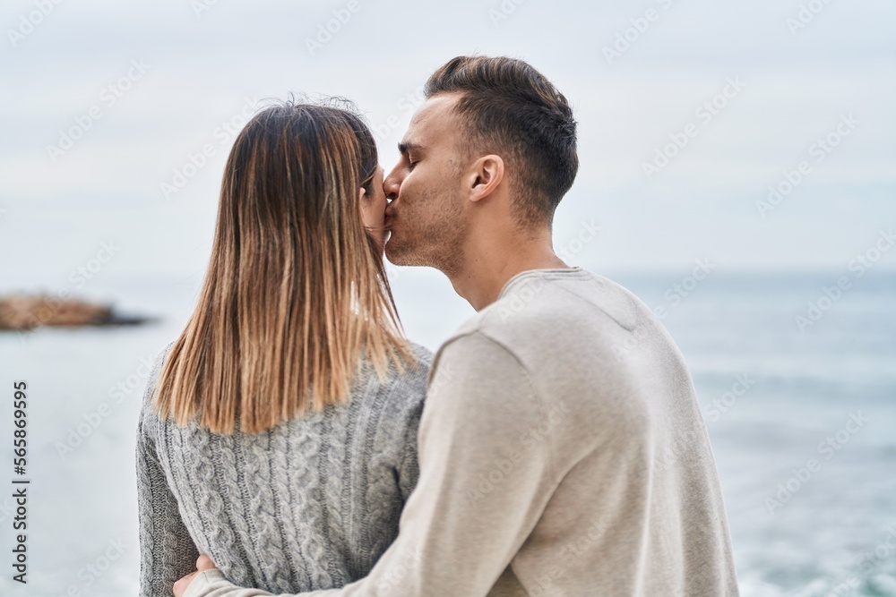 Man and woman couple hugging each other on back view at seaside Man and woman couple hugging each other on back view at seaside