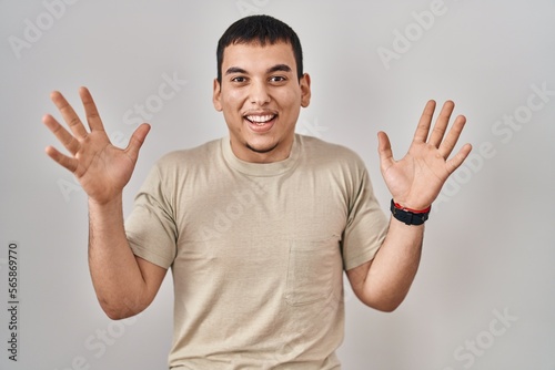 Young arab man wearing casual t shirt celebrating crazy and amazed for success with arms raised and open eyes screaming excited. winner concept © Krakenimages.com