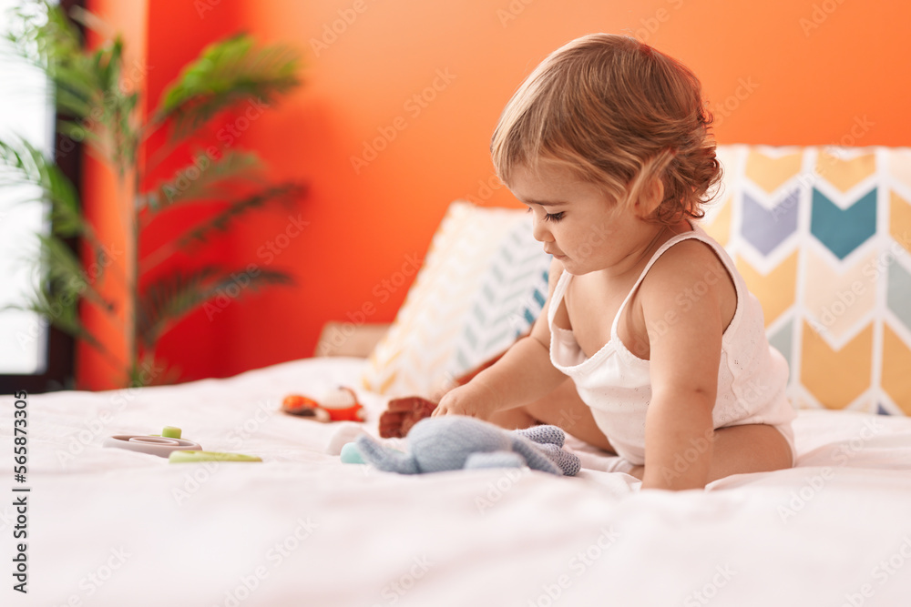 Adorable hispanic toddler sitting on bed with relaxed expression at bedroom Adorable hispanic toddler sitting on bed with relaxed expression at bedroom