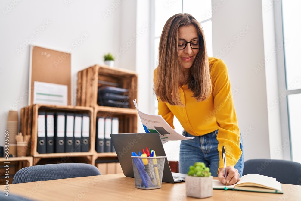 Young woman business worker writing on notebook working at office Young woman business worker writing on notebook working at office