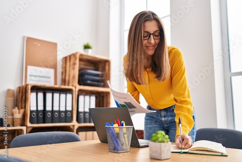 Young woman business worker writing on notebook working at office