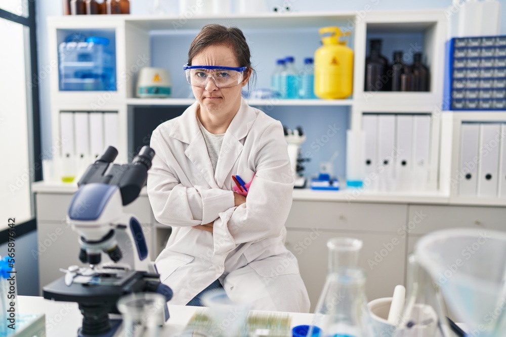 Hispanic girl with down syndrome working at scientist laboratory skeptic and nervous, disapproving expression on face with crossed arms. negative person. Hispanic girl with down syndrome working at scientist laboratory skeptic and nervous, disapproving expression on face with crossed arms. negative person.