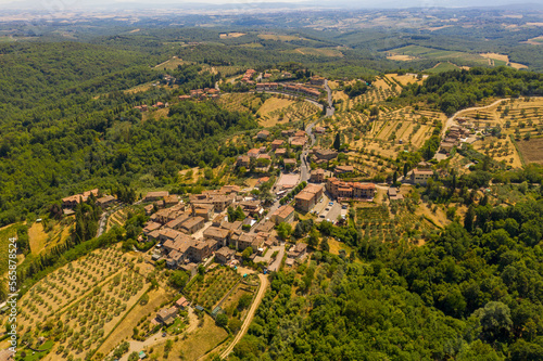 Drone photography of small rural town surrounded by agricultural fields, vineyards and olive trees