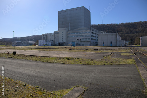 Würgassen, Germany - 03 23 2020: Main reactor building with surrounding gras, rails and a blue sky
