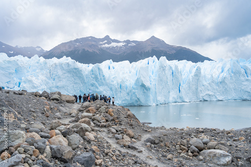 A lo lejos se ve un grupo de personas que se dirige caminando a recorrer el imponente glaciar Perito Moreno de Argentina.