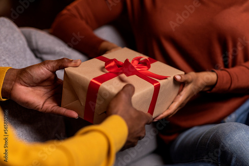Unrecognizable man and woman holding gift box, cropped