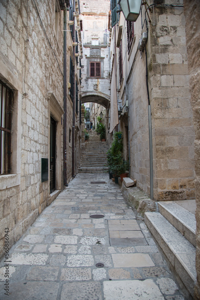 Fototapeta premium Picturesque small alley with houses, stairway and pathway made of stone or limestone in the old town of Dubrovnik, Croatia