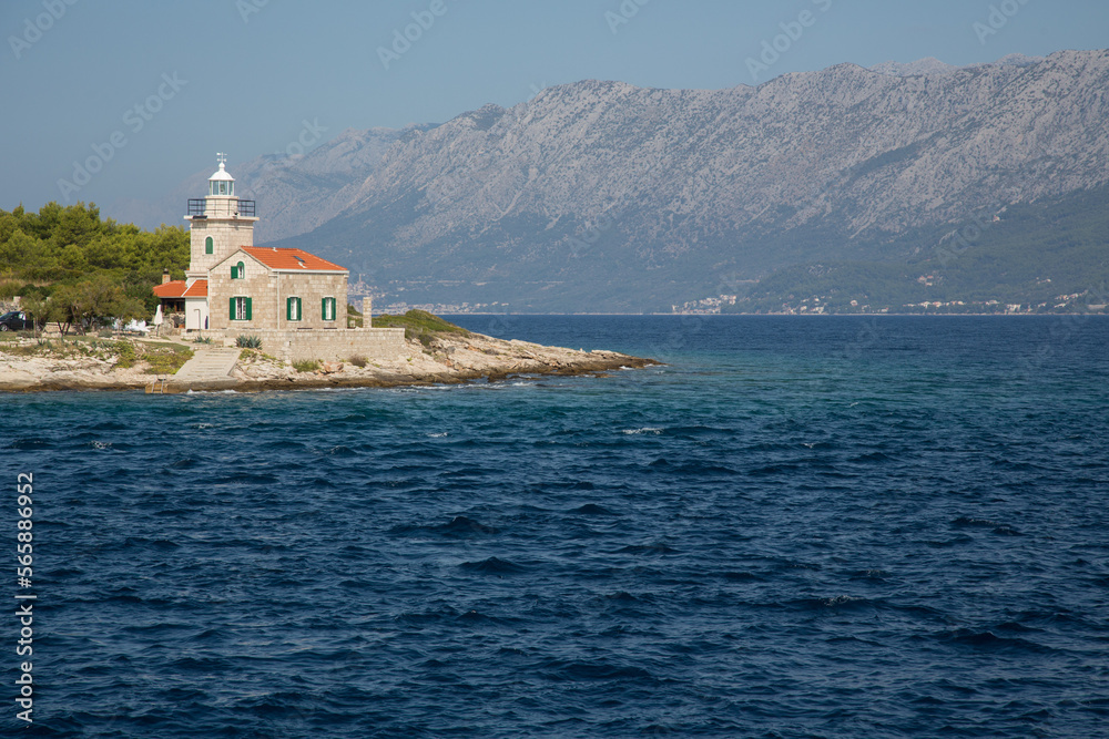 Passing the lighthouse of Sućuraj on the eastern part of the island Hvar, Dalmatia, Croatia with the Biokovo mountain range on the mainland in the background