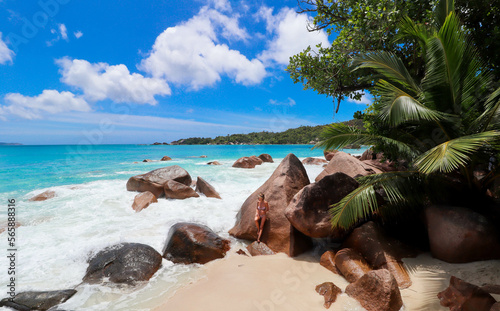 Woman looking at the savage waves in the beach tropical forest of Seychelles