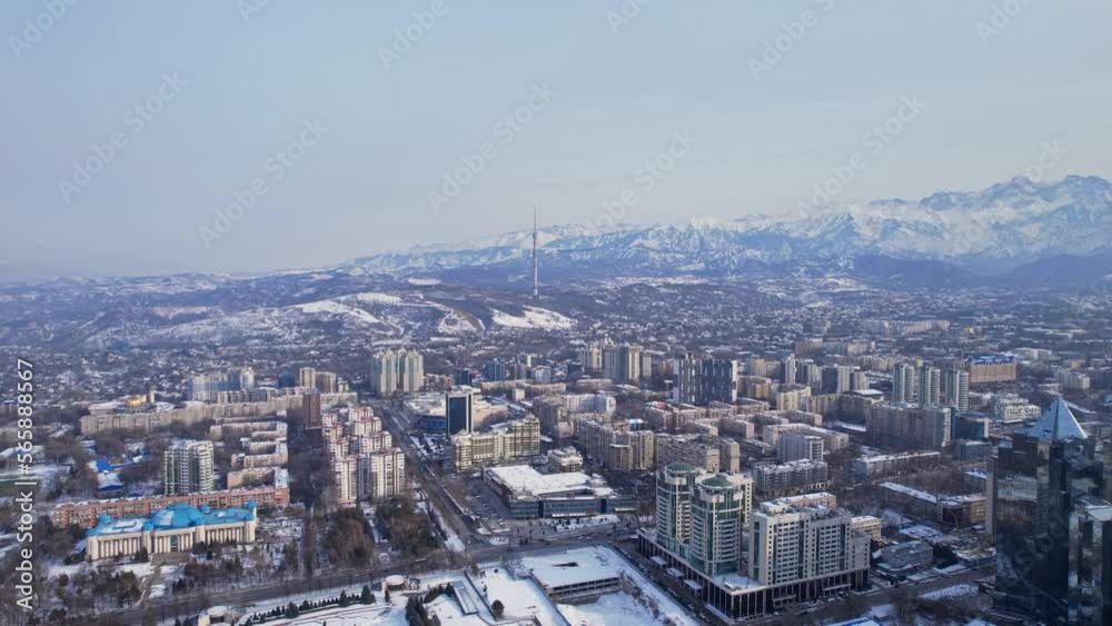 The video features a drone flying over a city with towering business centers and breathtaking views of mountains in the background. The video features a drone flying over a city with towering business centers and breathtaking views of mountains in the background.