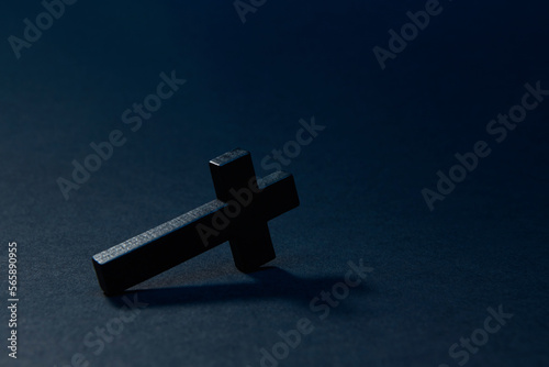 Photo Black wooden traditional cross fallen down and lying on edge at an angle on the