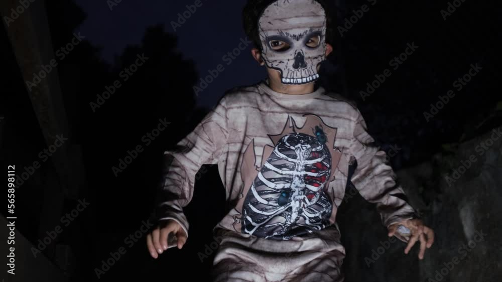 Boy dressed as mummy with illuminated halloween pumpkin with bela at night terror trick or treat hallowen autumn celebration Boy dressed as mummy with illuminated halloween pumpkin with bela at night terror trick or treat hallowen autumn celebration