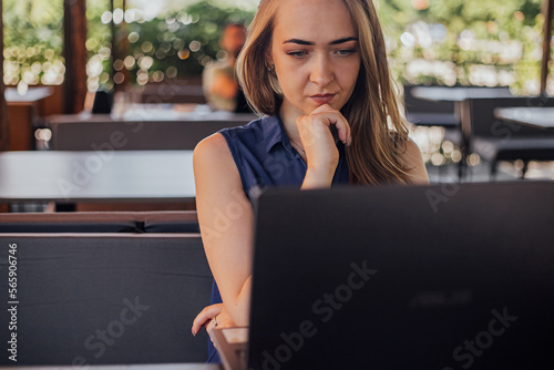 a girl sits on a summer terrace and works at a laptop. freelance. selfeducation. the concept of remote learning and outdoor work. Free Download a girl sits on a summer terrace and works at a laptop. freelance. selfeducation. the concept of remote learning and outdoor work. - GFXLoad