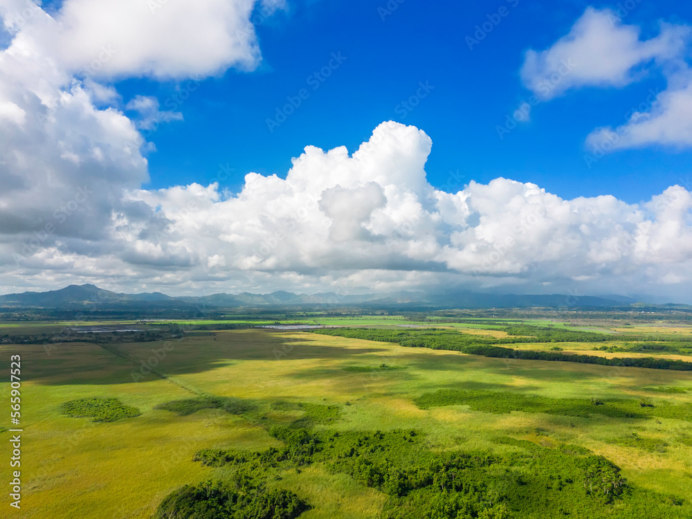 Aerial view of green meadows and mountains in the background and cloudy blue sky. The beautiful nature of the Dominican Republic Aerial view of green meadows and mountains in the background and cloudy blue sky. The beautiful nature of the Dominican Republic