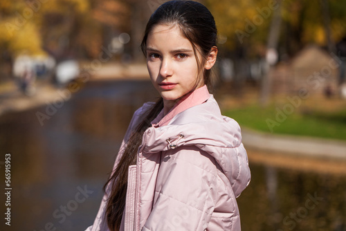 Portrait of a young beautiful brunette woman in autumn park
