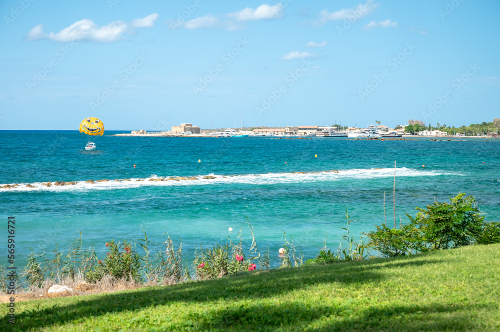Obraz premium Vacation resorts on Cyprus near Paprhos with green grass, beach umbrellas, beds, beaches and palm trees, travel destination in EU, Cyprus