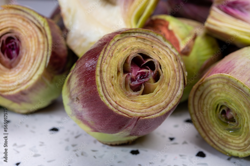 Heads of raw fresh purple romanesco artichoke vegetable and pilled hearts
